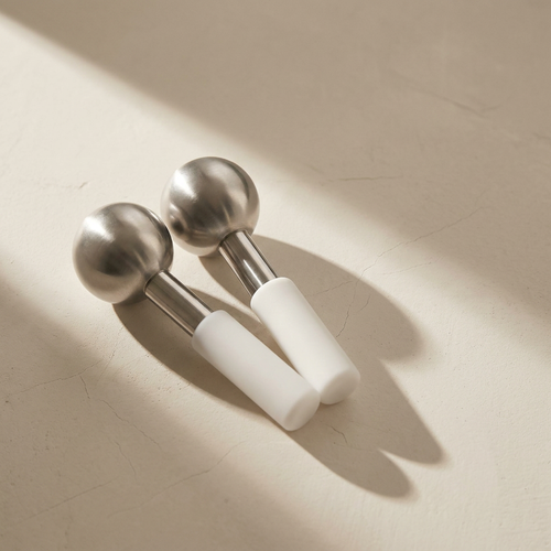Lumi Cryo Ice Globes, unbreakable stainless steel, on a bone plaster counter in window light