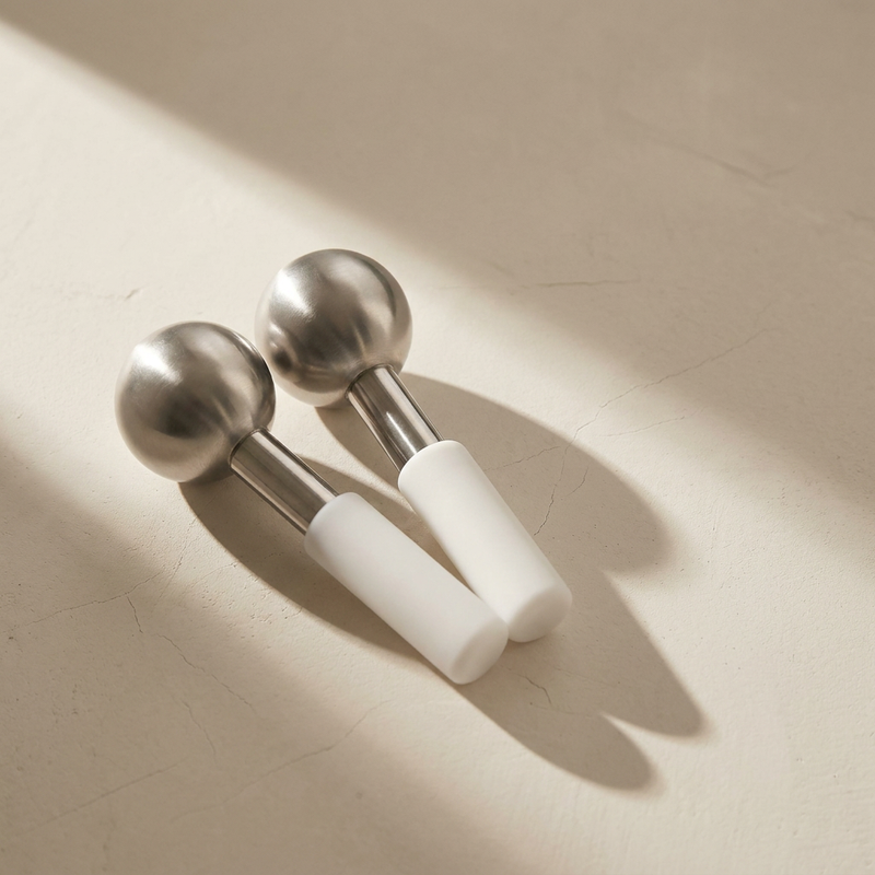 Lumi Cryo Ice Globes, unbreakable stainless steel, on a bone plaster counter in window light