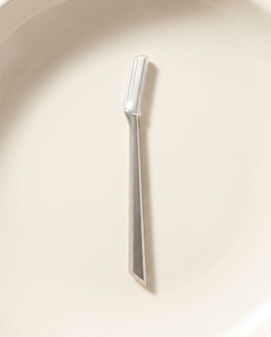 Dermaplaning Tool, bright morning light on warm porcelain